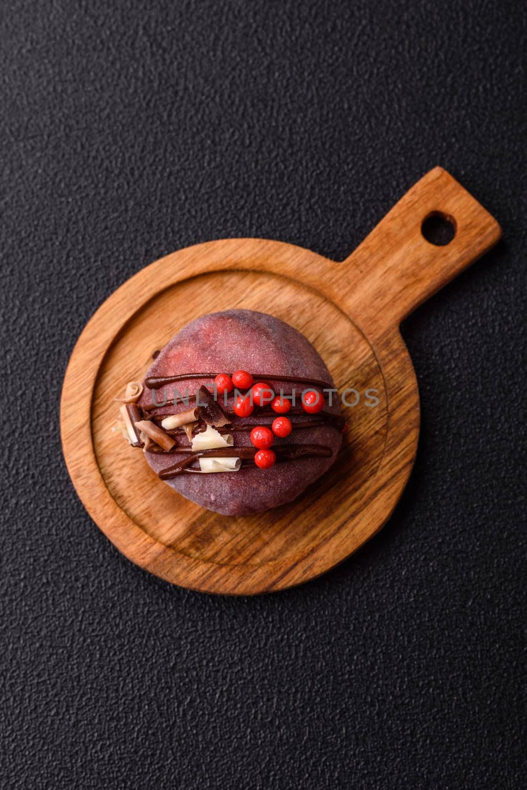Delicious colorful asian mochi sweets with rice dough shell and fruit filling on dark concrete background