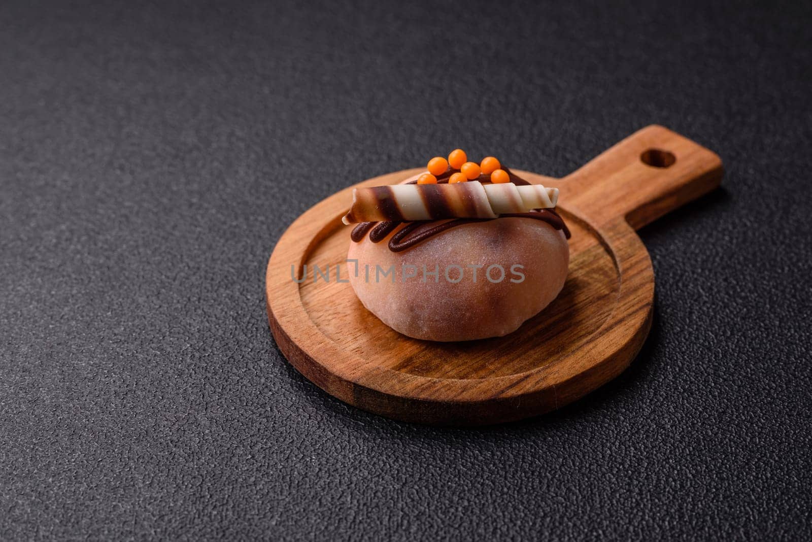 Delicious colorful asian mochi sweets with rice dough shell and fruit filling on dark concrete background