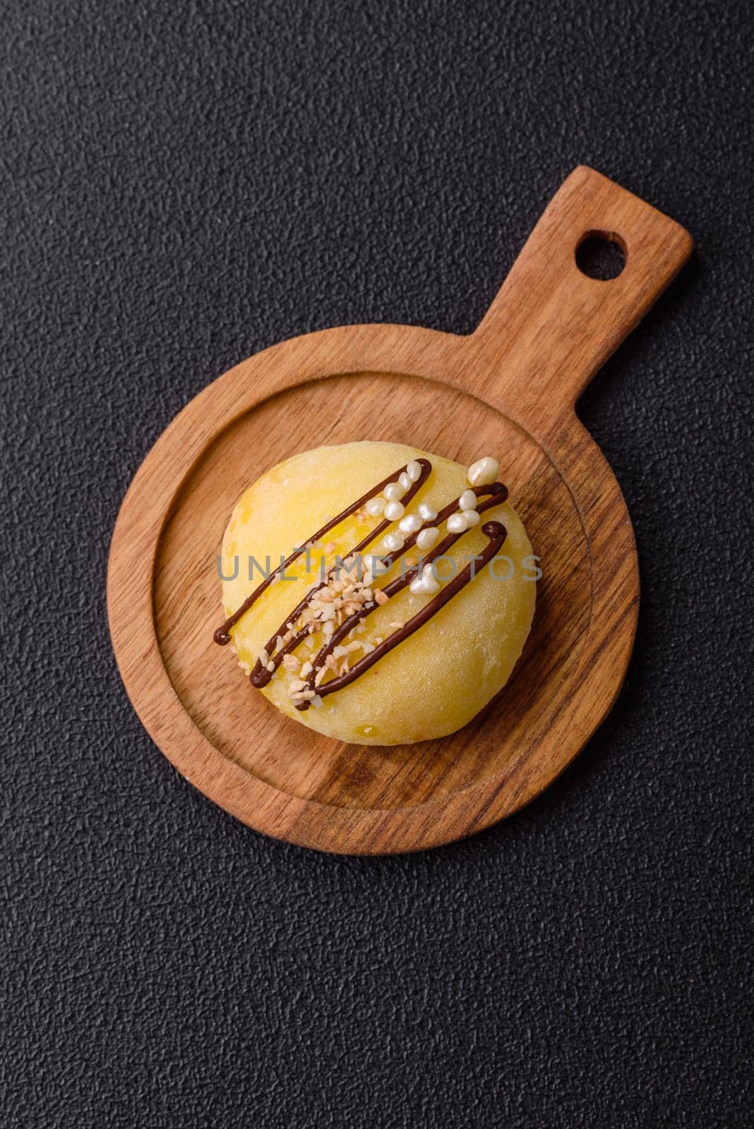 Delicious colorful asian mochi sweets with rice dough shell and fruit filling on dark concrete background