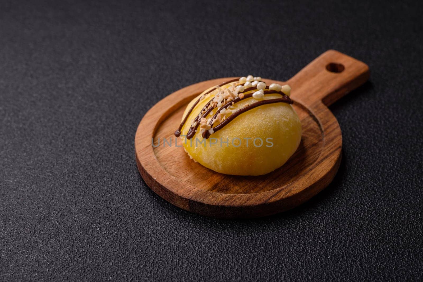Delicious colorful asian mochi sweets with rice dough shell and fruit filling on dark concrete background