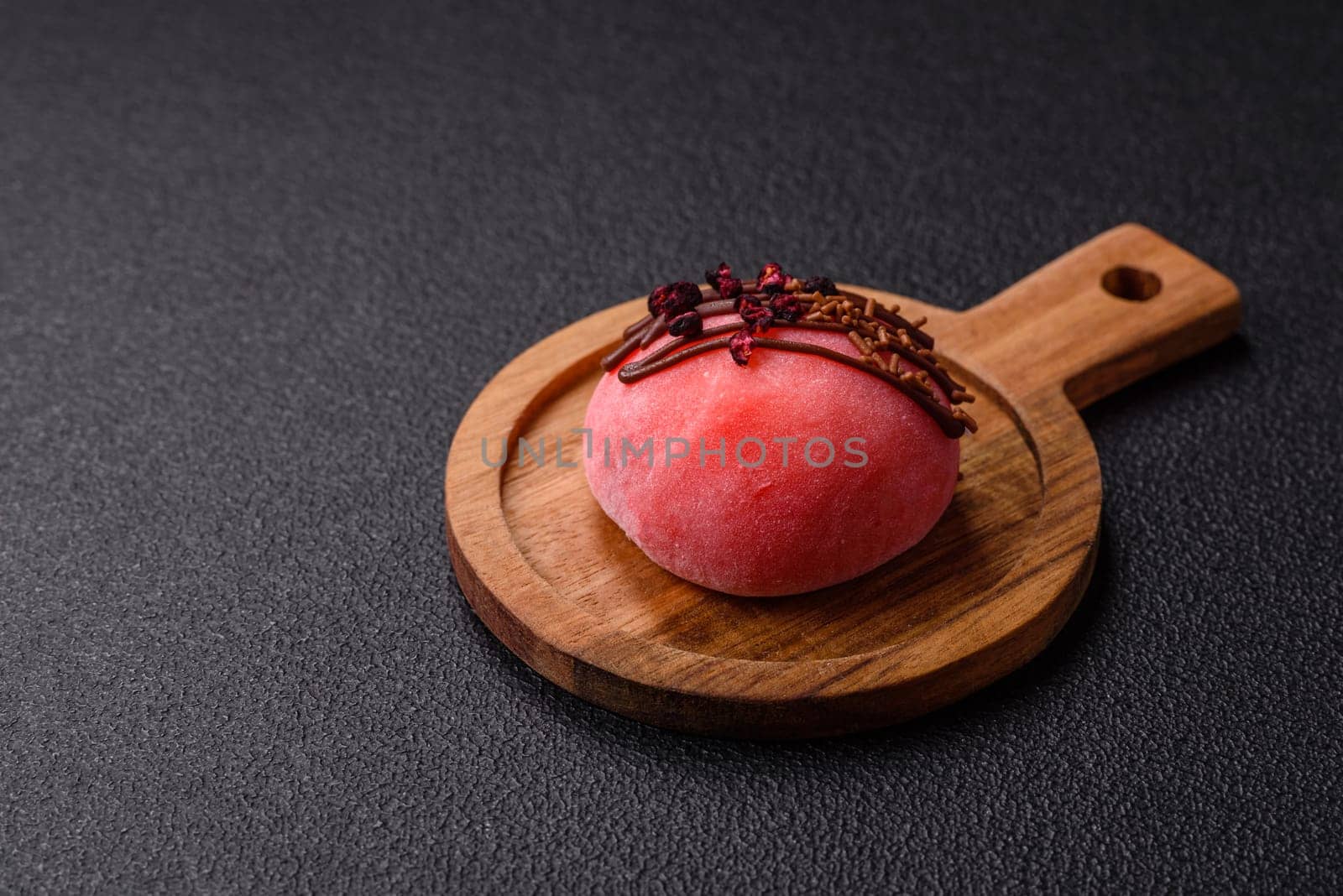 Delicious colorful asian mochi sweets with rice dough shell and fruit filling on dark concrete background
