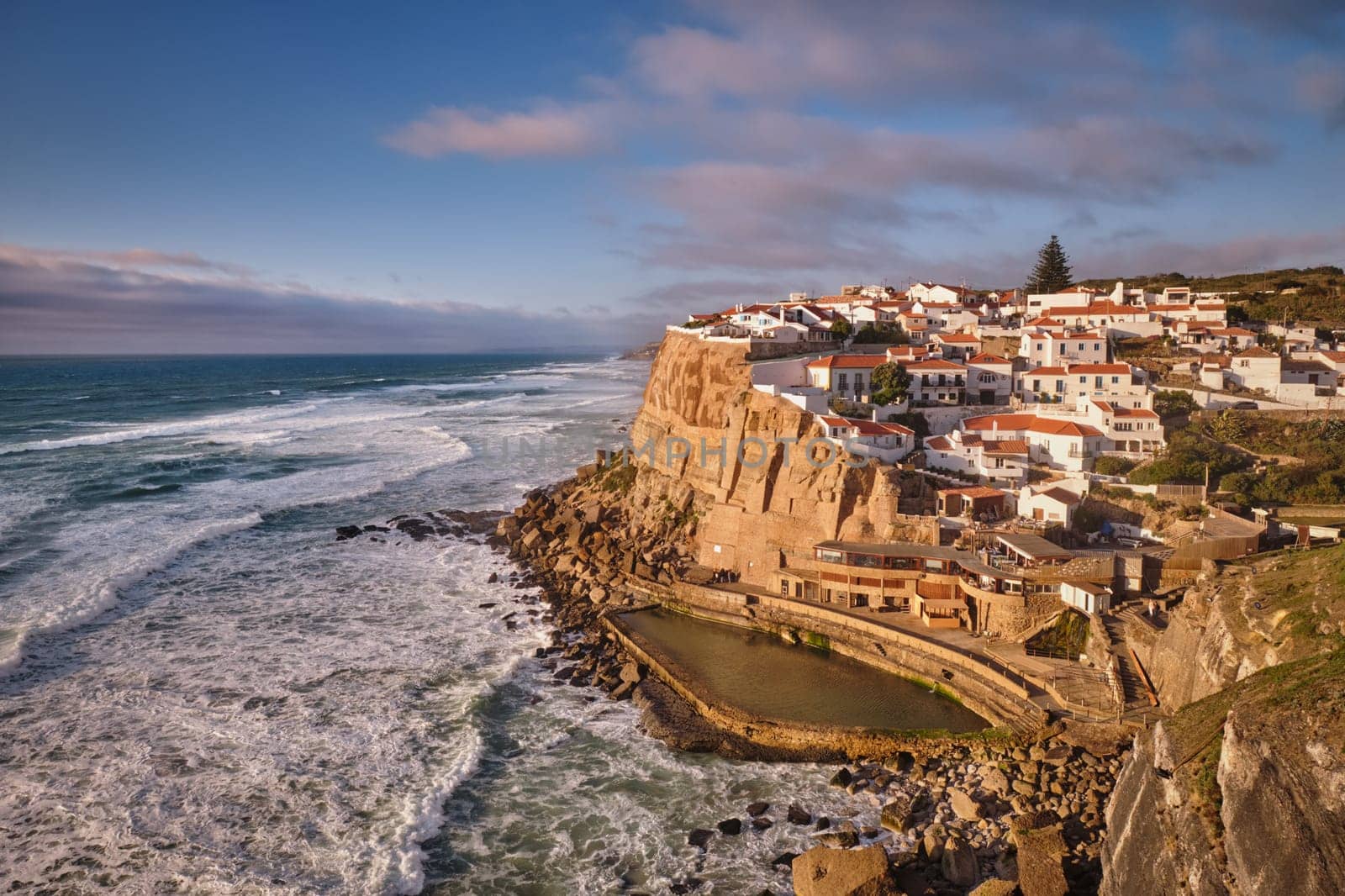 Scenic view of the seaside Azenhas do Mar fishing village on cliff on Atlantic ocean coast, Portugal on sunset