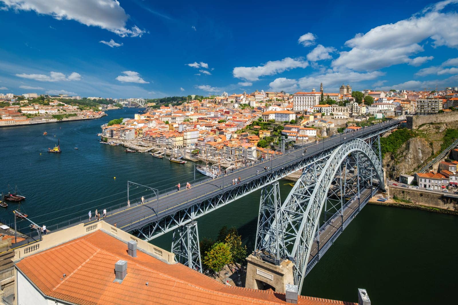 View of Porto city and Douro river with moored sailing ship and Dom Luis bridge I from famous tourist viewpoint Miradouro da Serra do Pilar on sunset. Porto, Vila Nova de Gaia, Portugal