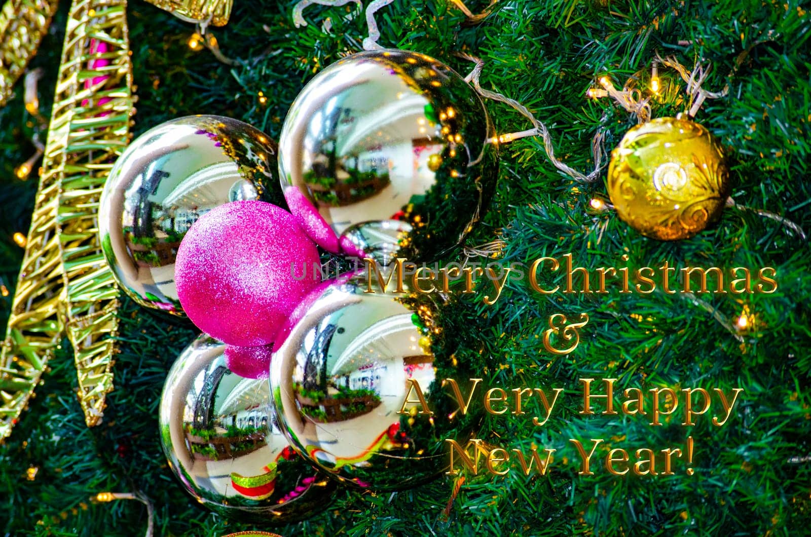 Golden Merry Christmas and Happy New Year Wishes text with Christmas ball and pine tree background. Christmas celebration concept.