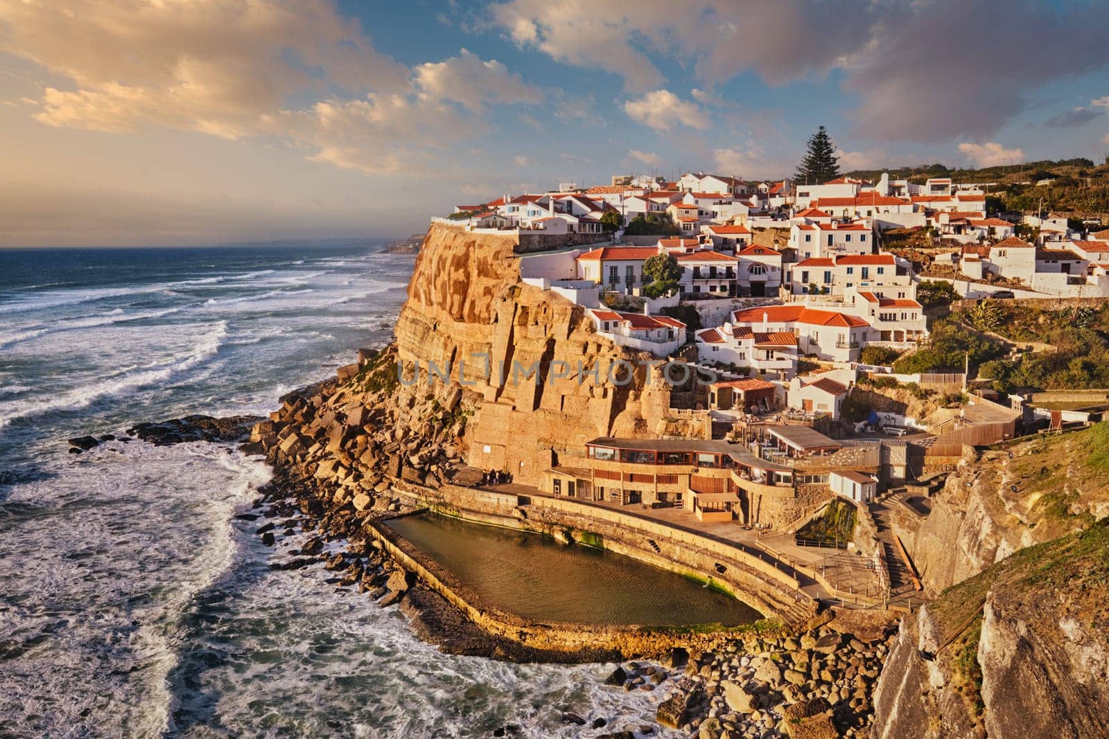Scenic view of the seaside Azenhas do Mar fishing village on cliff on Atlantic ocean coast, Portugal on sunset