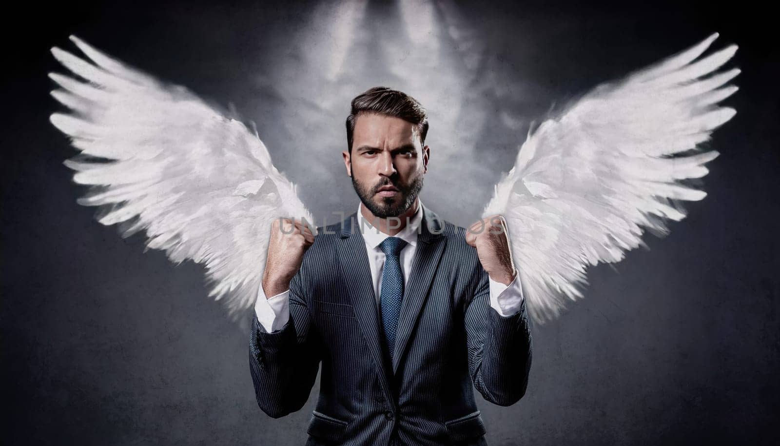 Business person in a suit with large white angel wings extending from his back. Businessman standing with fists raised showing his power as celebrating success