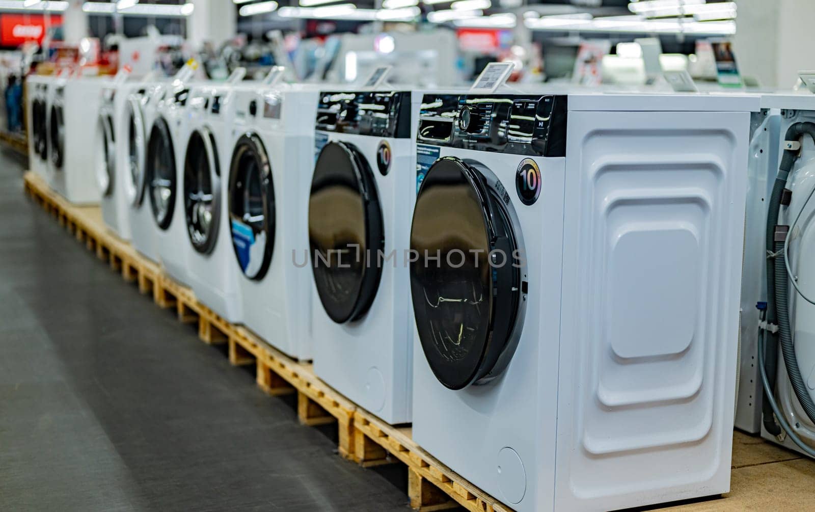 POZNAN, POL - DEC 5, 2024: Front-loader washing machines put up for sale in a household goods store