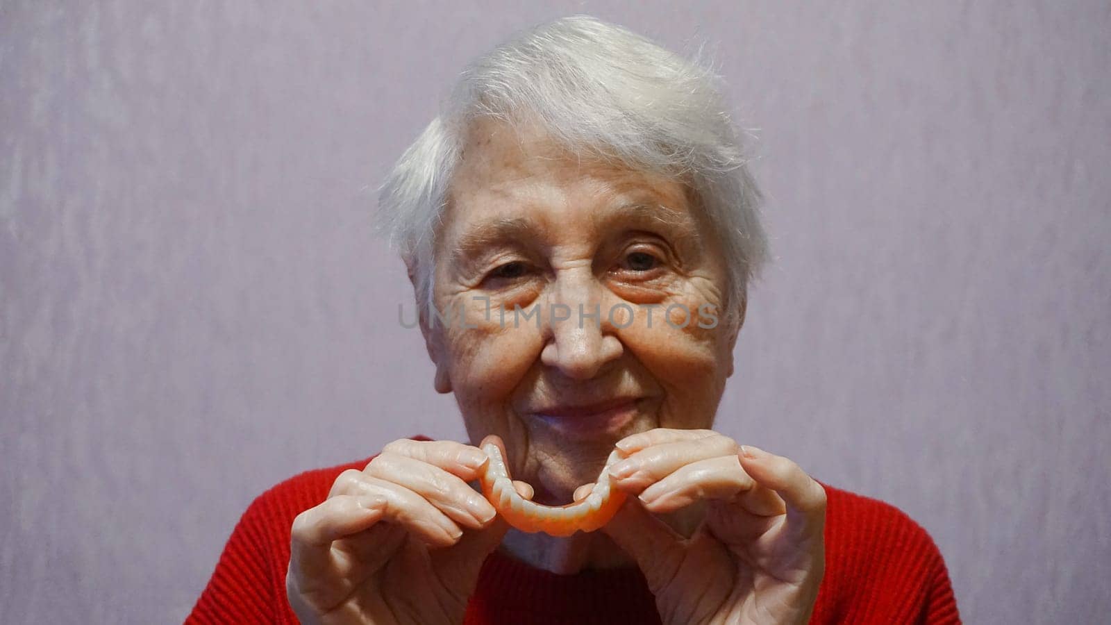flexible nylon denture on senior female hands. Removable dentures flexible, devoid of nylon, hypoallergenic exempt from monomer