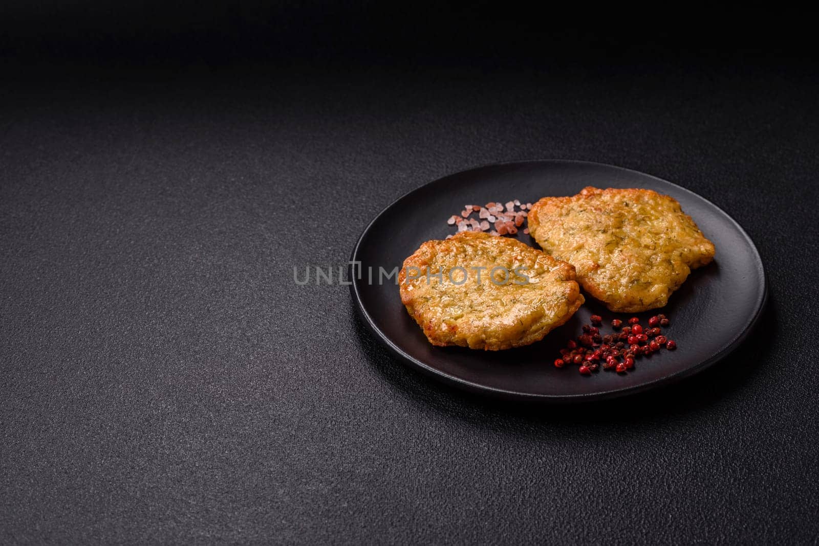 Delicious fried pork or chicken chops breaded with salt and spices on a dark concrete background