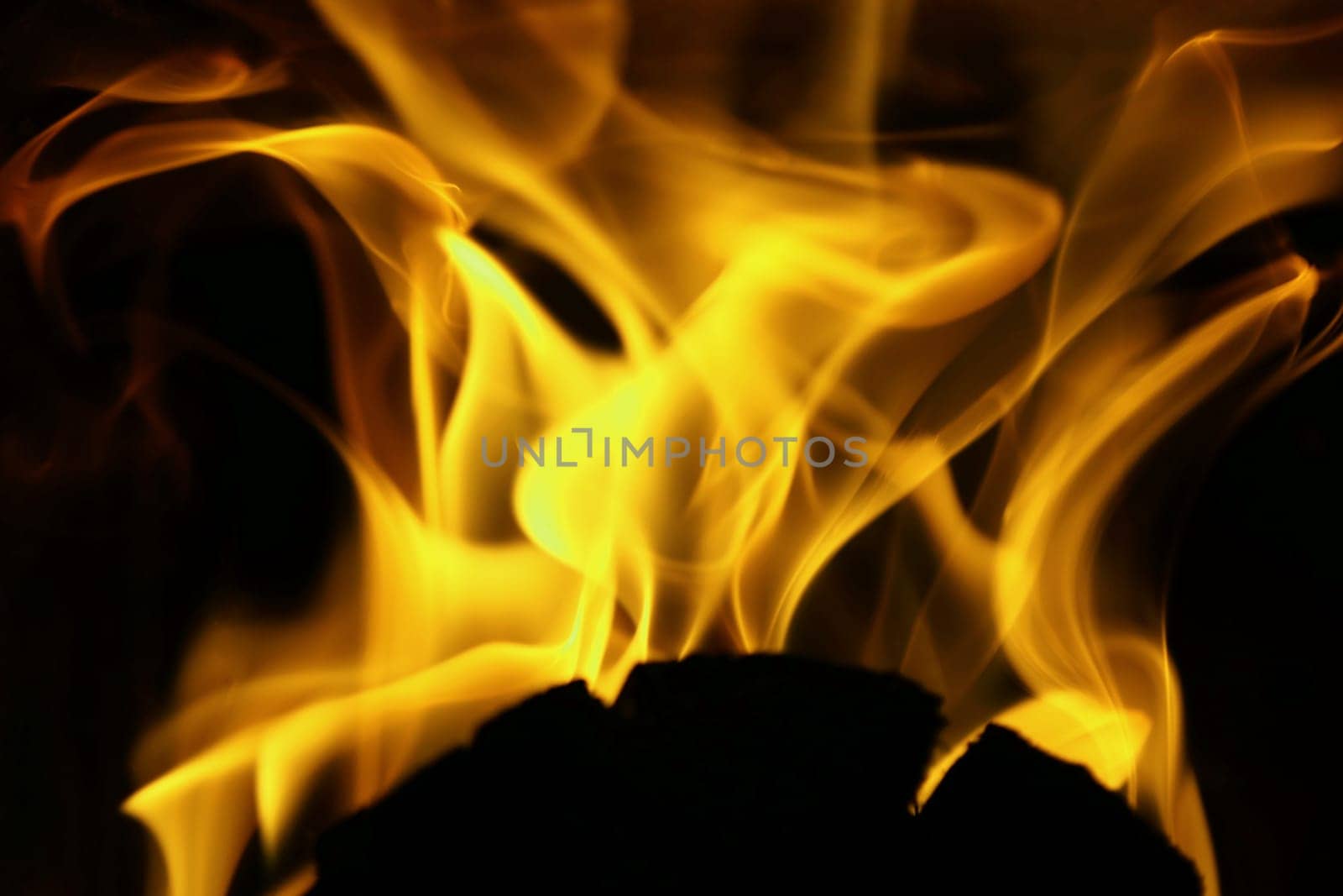 Flames from a fire in orange and gold against a black background