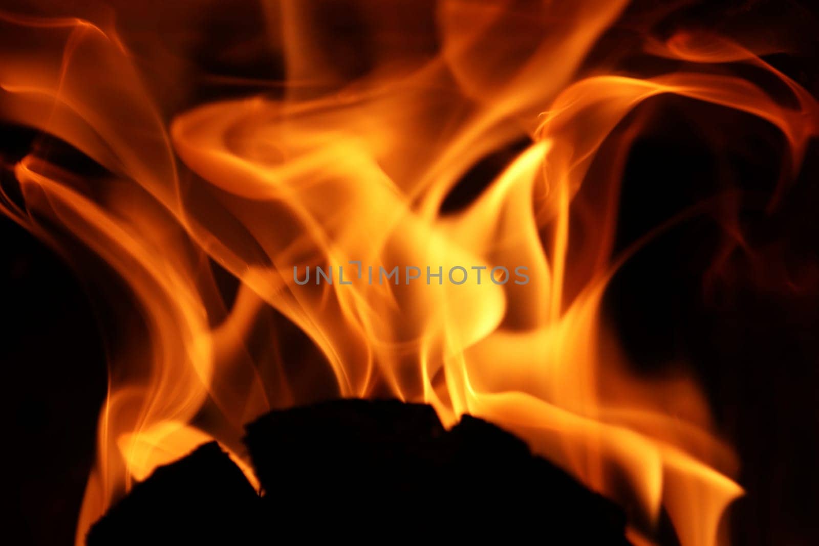 Flames from a fire in front of a black background