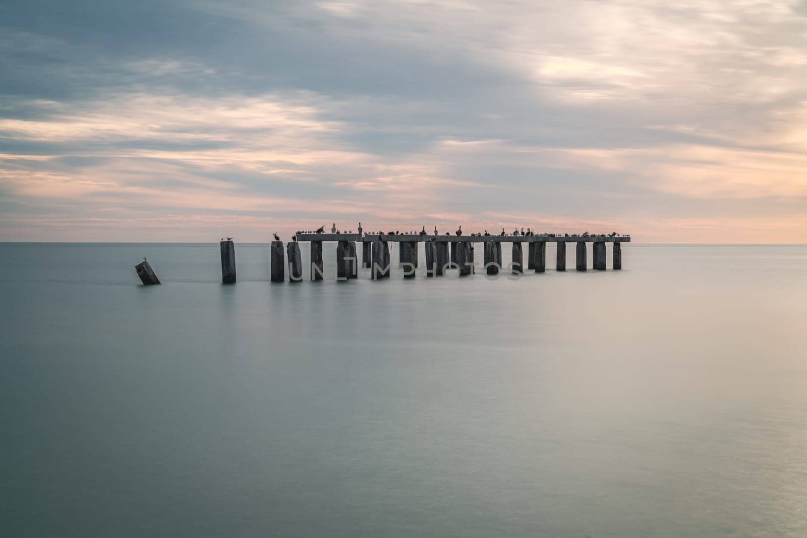 Scenic sunset over remnants of a pier in Boca Grande, Florida. Long exposure image