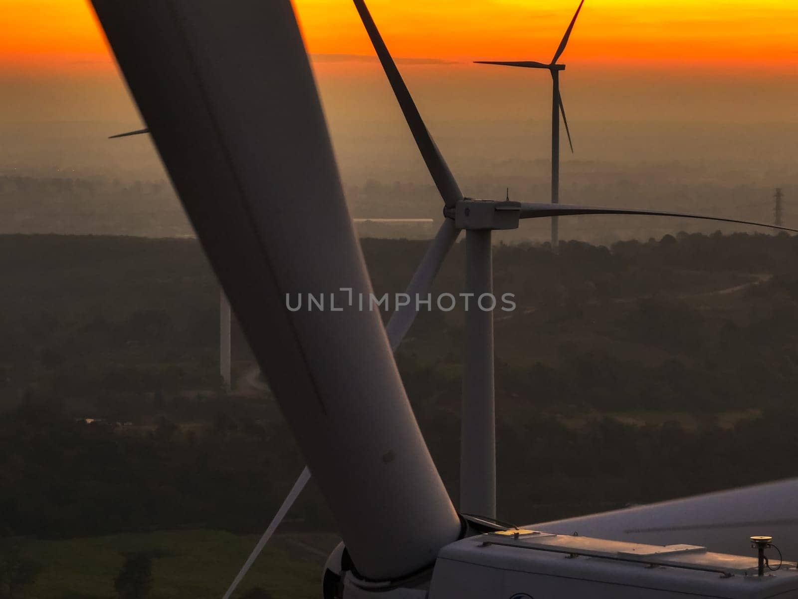 Wind farm field and sunset sky. Wind power. Sustainable, renewable energy. Wind turbines generate electricity. Sustainable development. Green technology for energy sustainability. Eco-friendly energy.