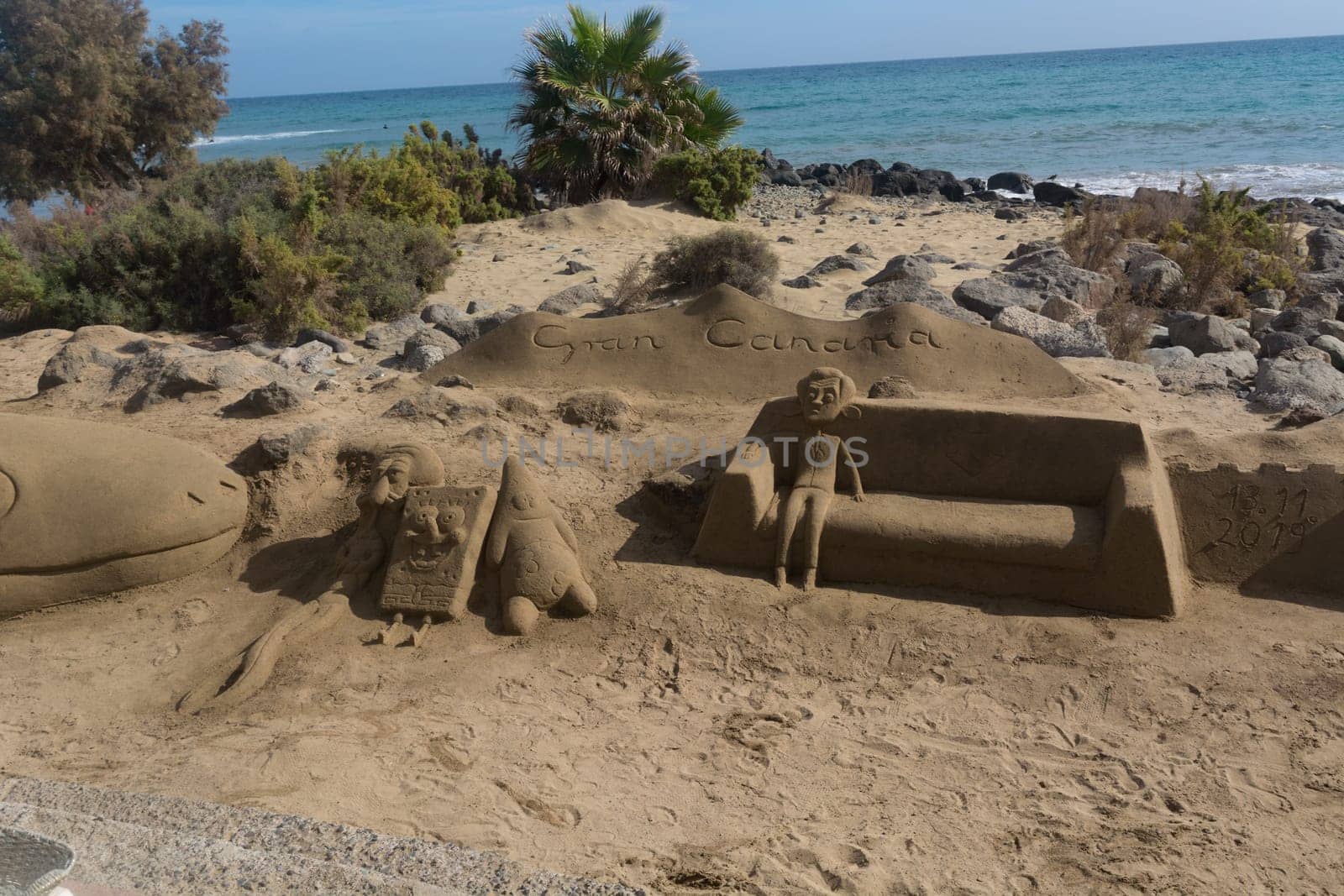 CRAN CANARIA, MELONERAS - 13. NOVEMBER 2019: Cran Canaria, Meloneras, Spanien - 13. November 2019: Sand sculptures on the beach of Meloneras, Spain with inscription Gran Canaria