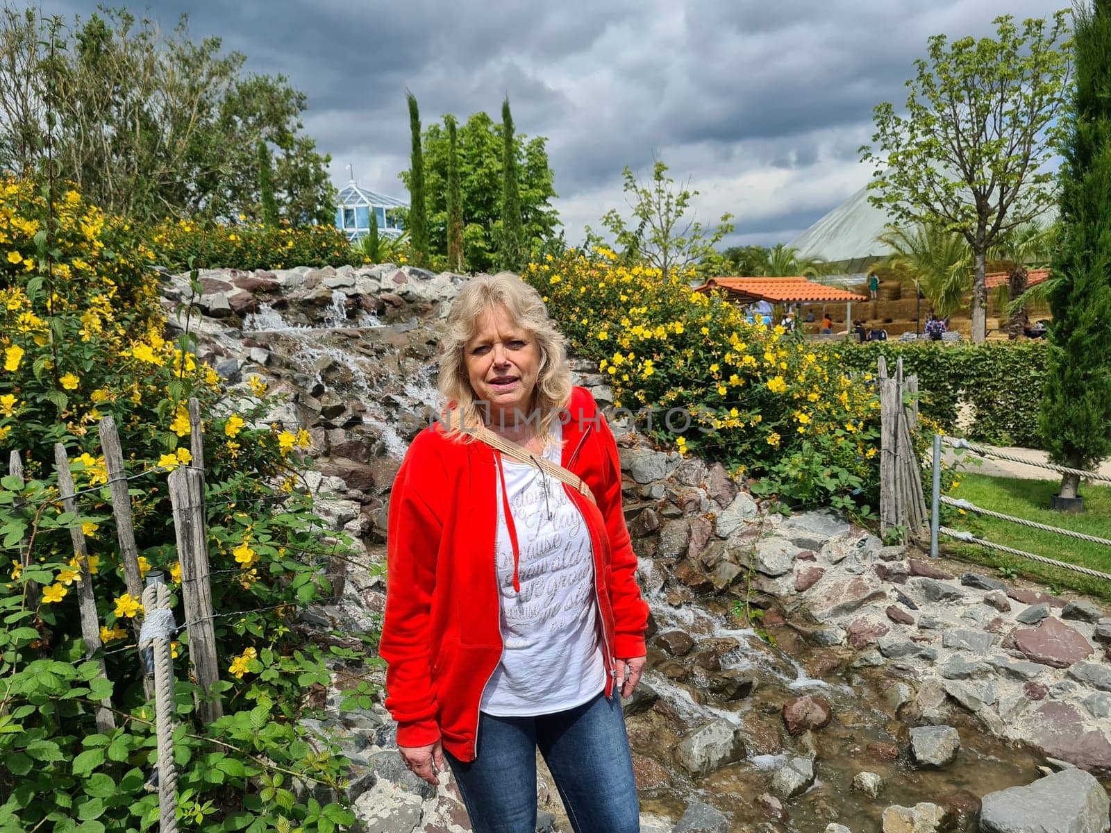HEILIGENHAUS, NRW, GERMANY - JULY 15, 2020: Heiligenhaus, Nrw, Germany - July 15, 2020: Beautiful and Happy Woman In Front Of A Waterfall