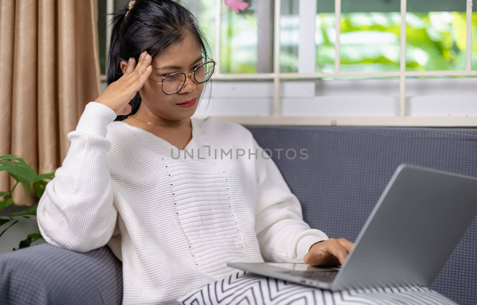 Woman working from home and have stress from work, Women working about new startup on laptop to analysis finance of project in outside office, Woman working using laptop online meeting in home office.
