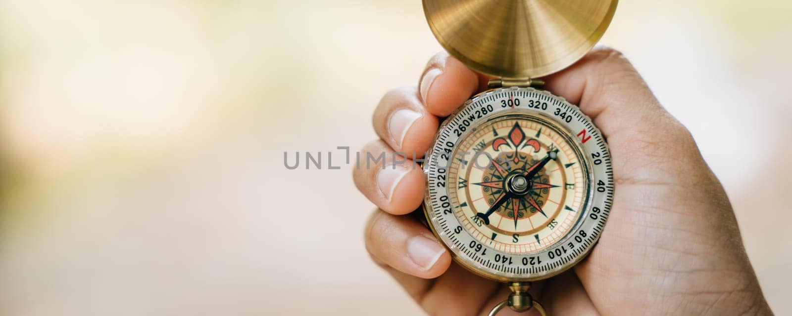 Amidst the forest's beauty a close-up reveals a woman using a compass during her hike. With determination she holds the compass highlighting guidance and exploration.