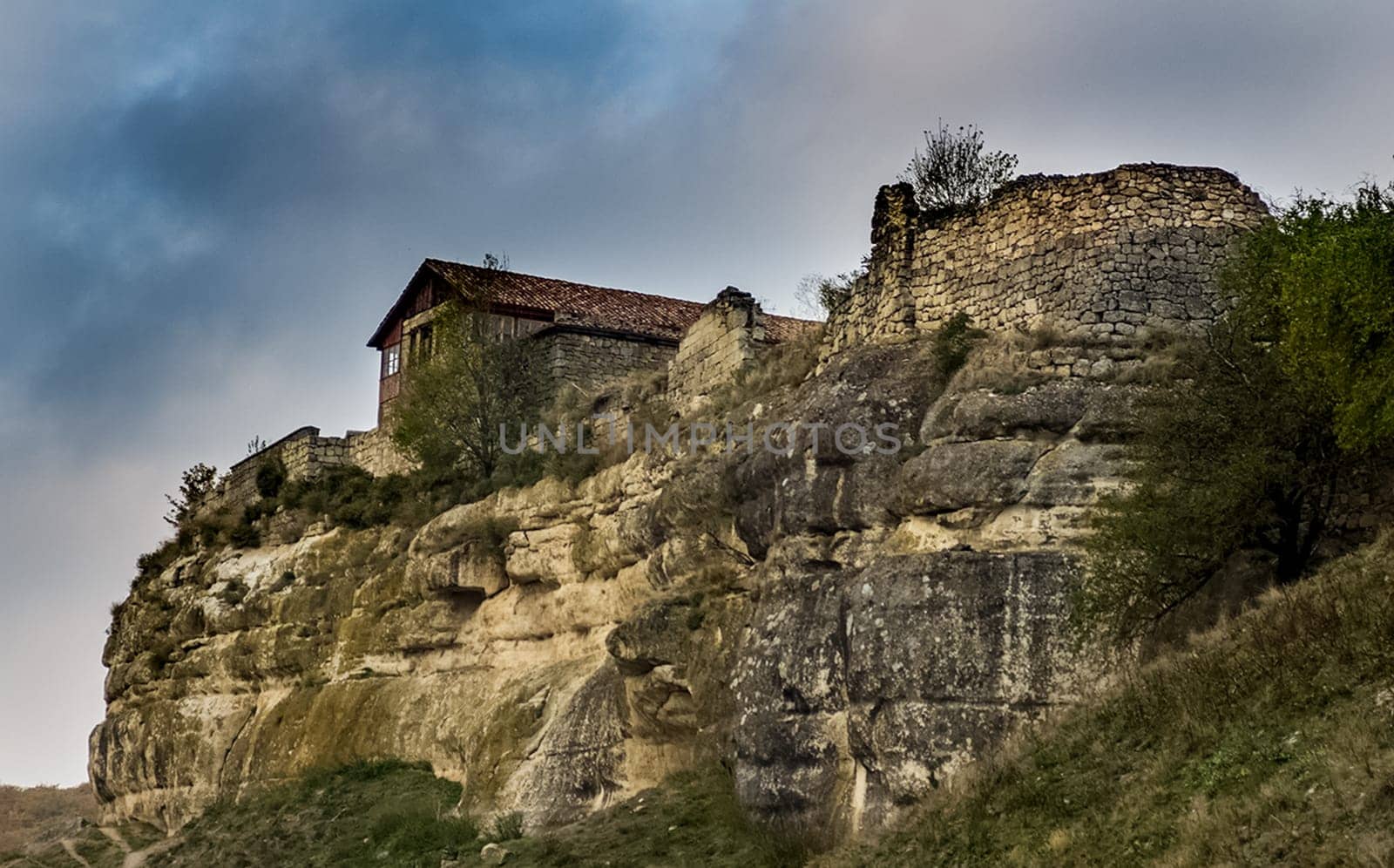 An old limestone house on a cliff on the edge of a cliff.