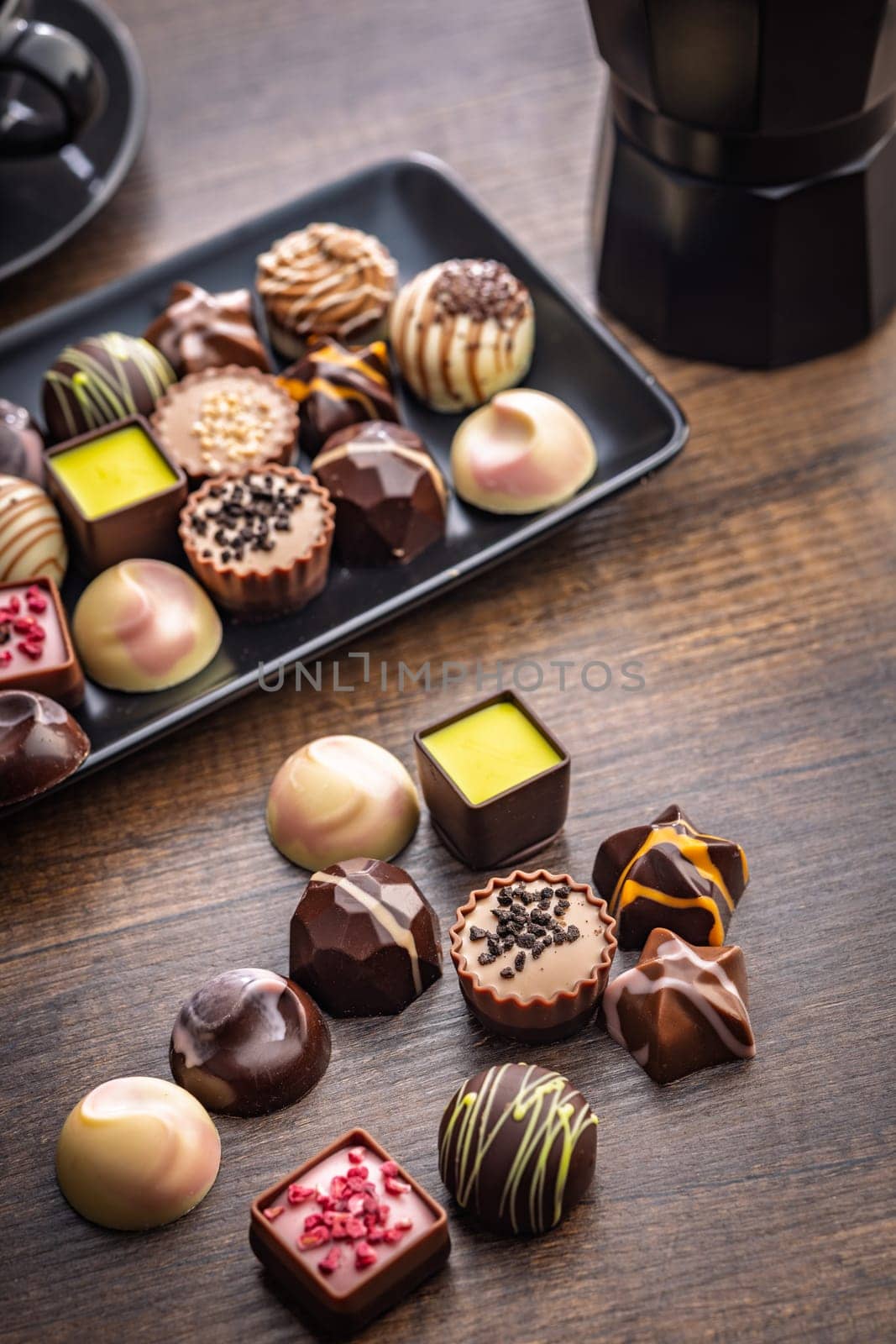 Mix of chocolate pralines on a wooden table.