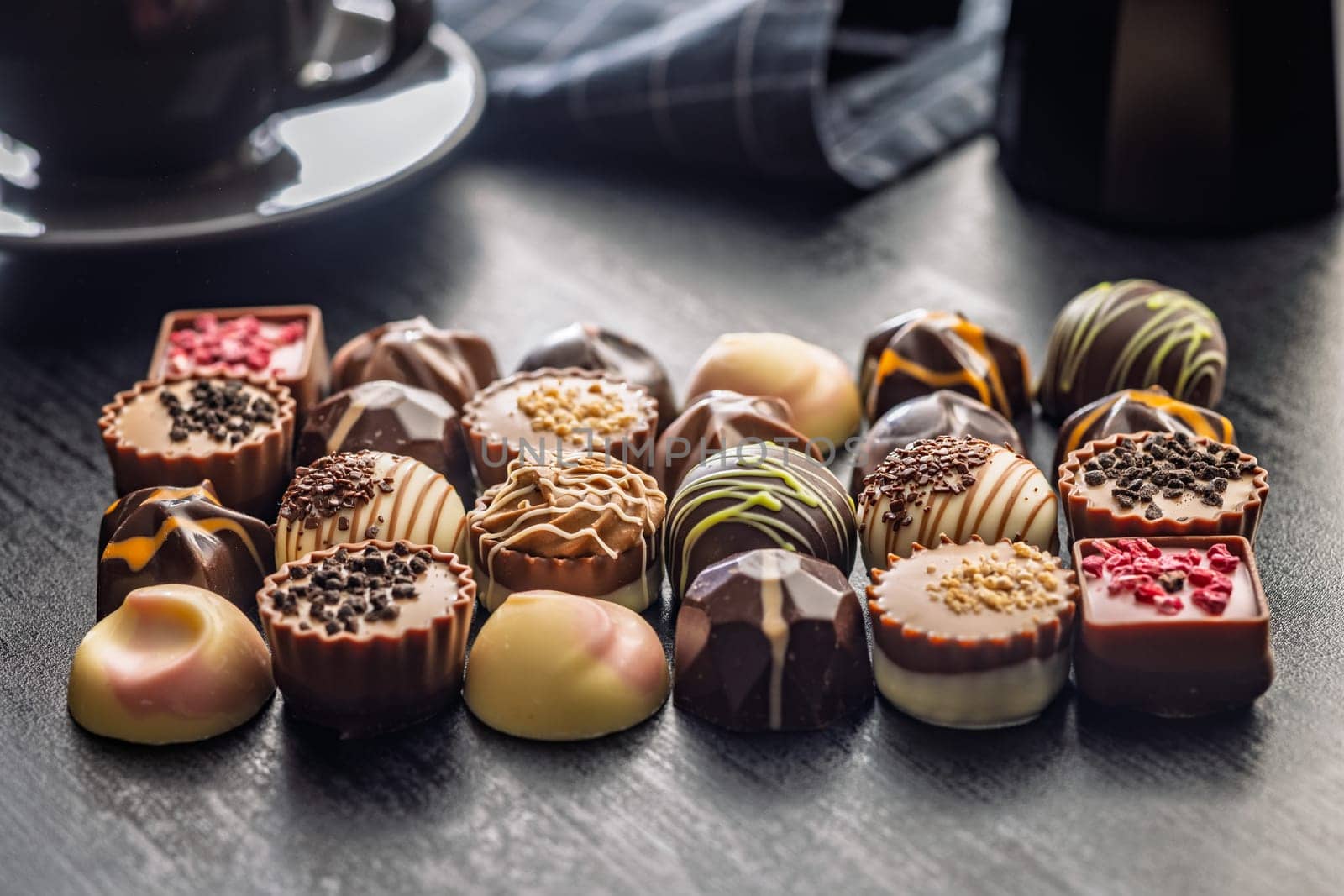 Mix of chocolate pralines on a black table.