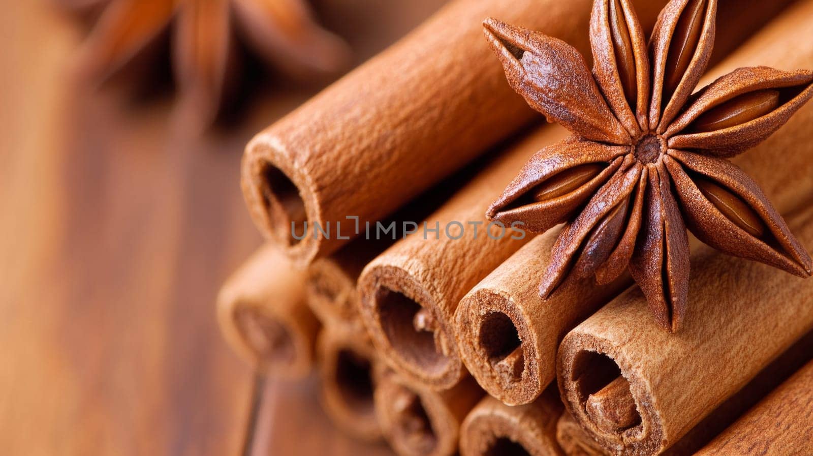 A detailed arrangement of cinnamon sticks and star anise, showcasing natural textures and warm tones, placed on a wooden surface.