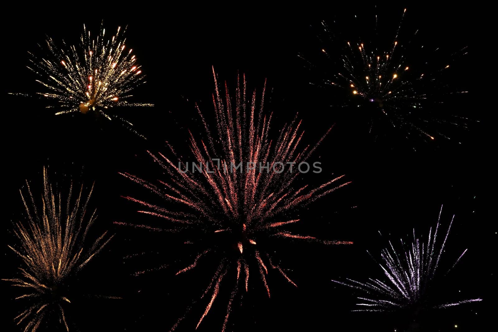 Turn of the year with various New Year's Eve rockets in the black sky