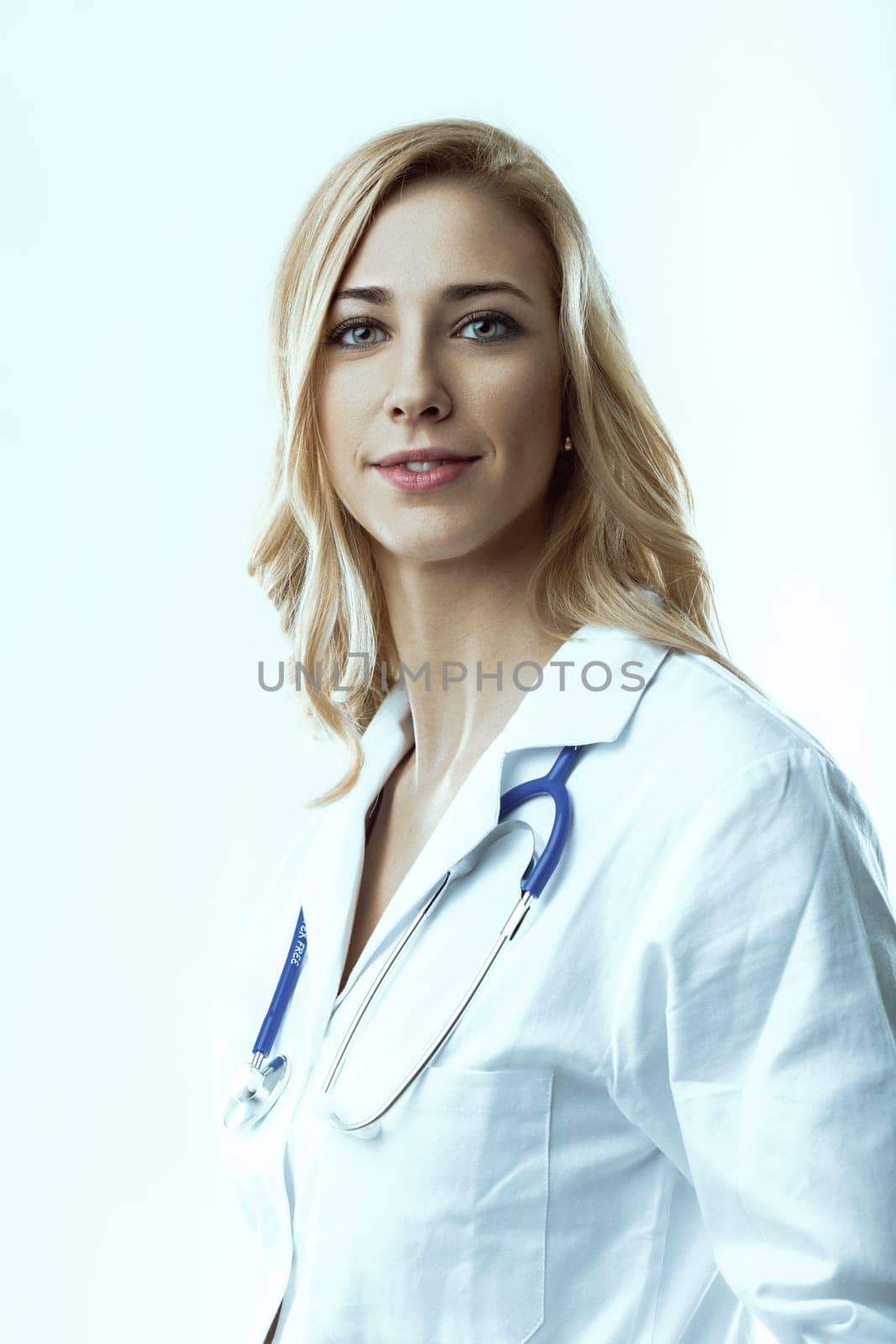 Friendly female doctor wearing a lab coat and stethoscope, smiling and looking directly at the camera, embodying the essence of healthcare and medicine with professionalism and care