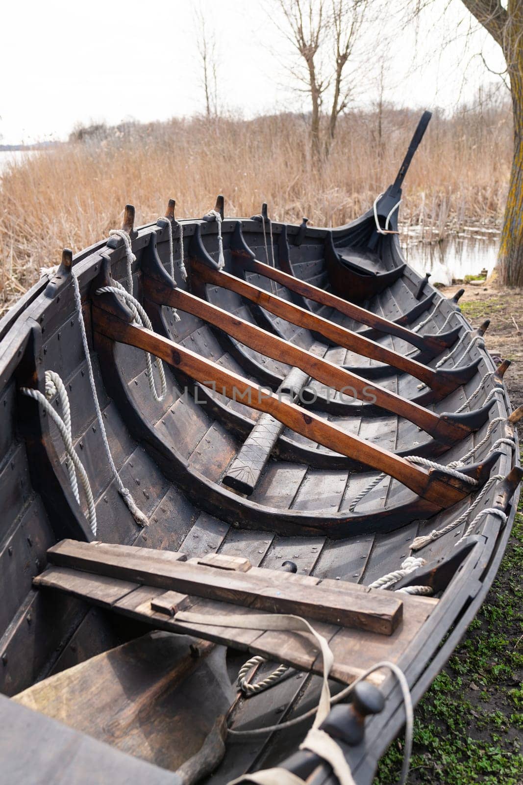 Detailed view of the interior of a Viking longboat, highlighting wooden ribs, ropes, and traditional construction techniques.