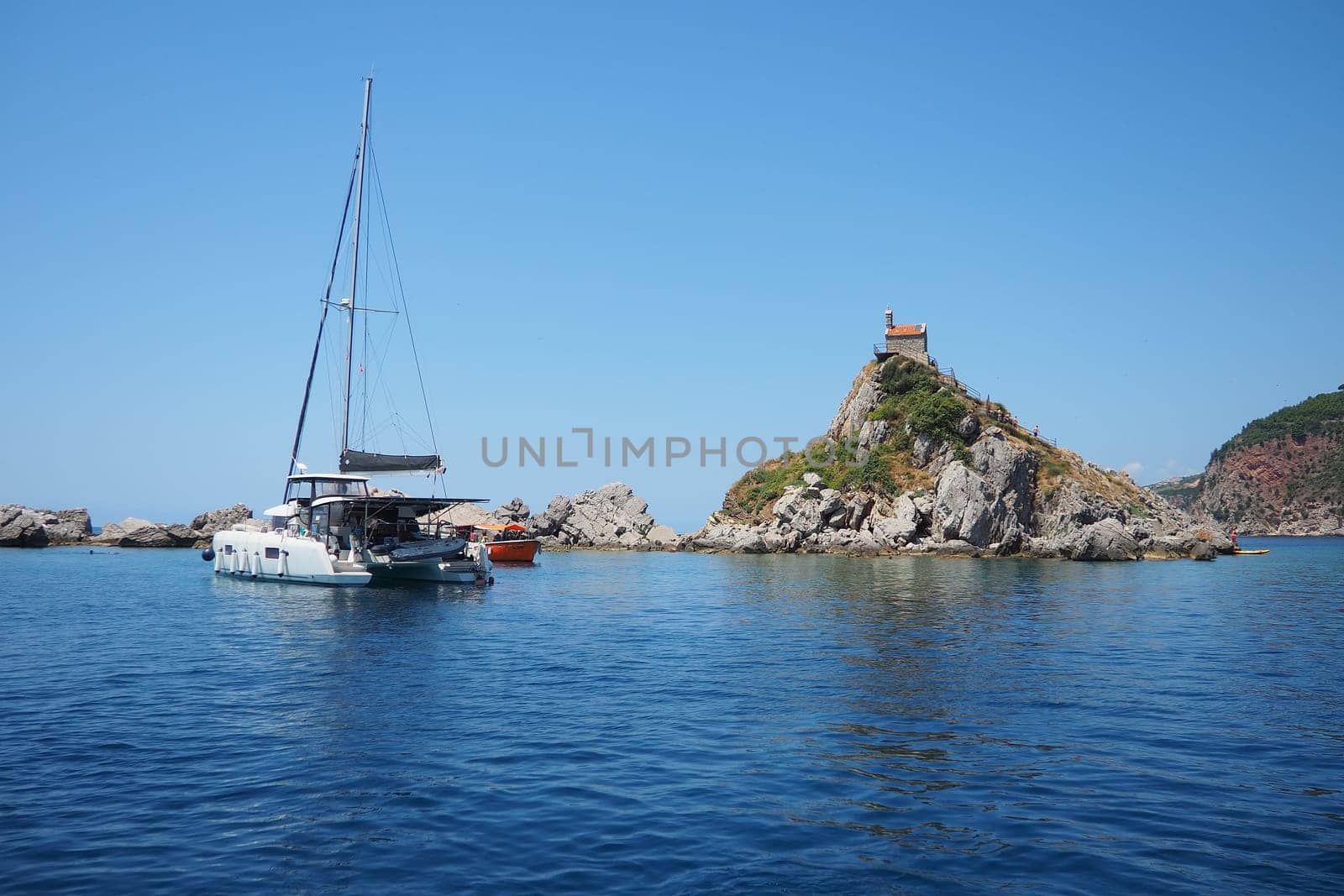 Petrovac, Montenegro, 07.27.24: Katic and Sveta Nedelja are two small islets on the Adriatic Sea, located opposite of the town of Petrovac in the Montenegrin municipality of Budva. Church on the rock.