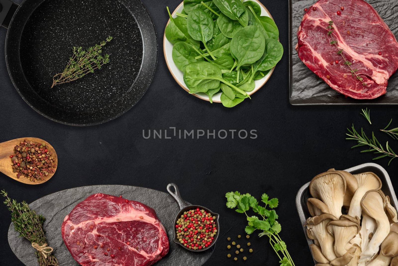 Empty frying pan, raw beef pieces, mushrooms and spices on black table, top view