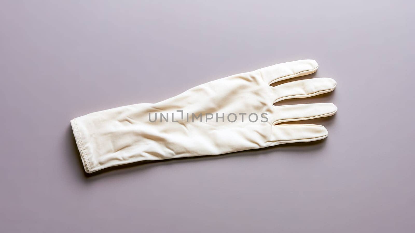 Single elegant cream colored glove rests on a simple, unadorned background, presenting a minimalist aesthetic with potential applications in fashion, accessories, or conceptual imagery
