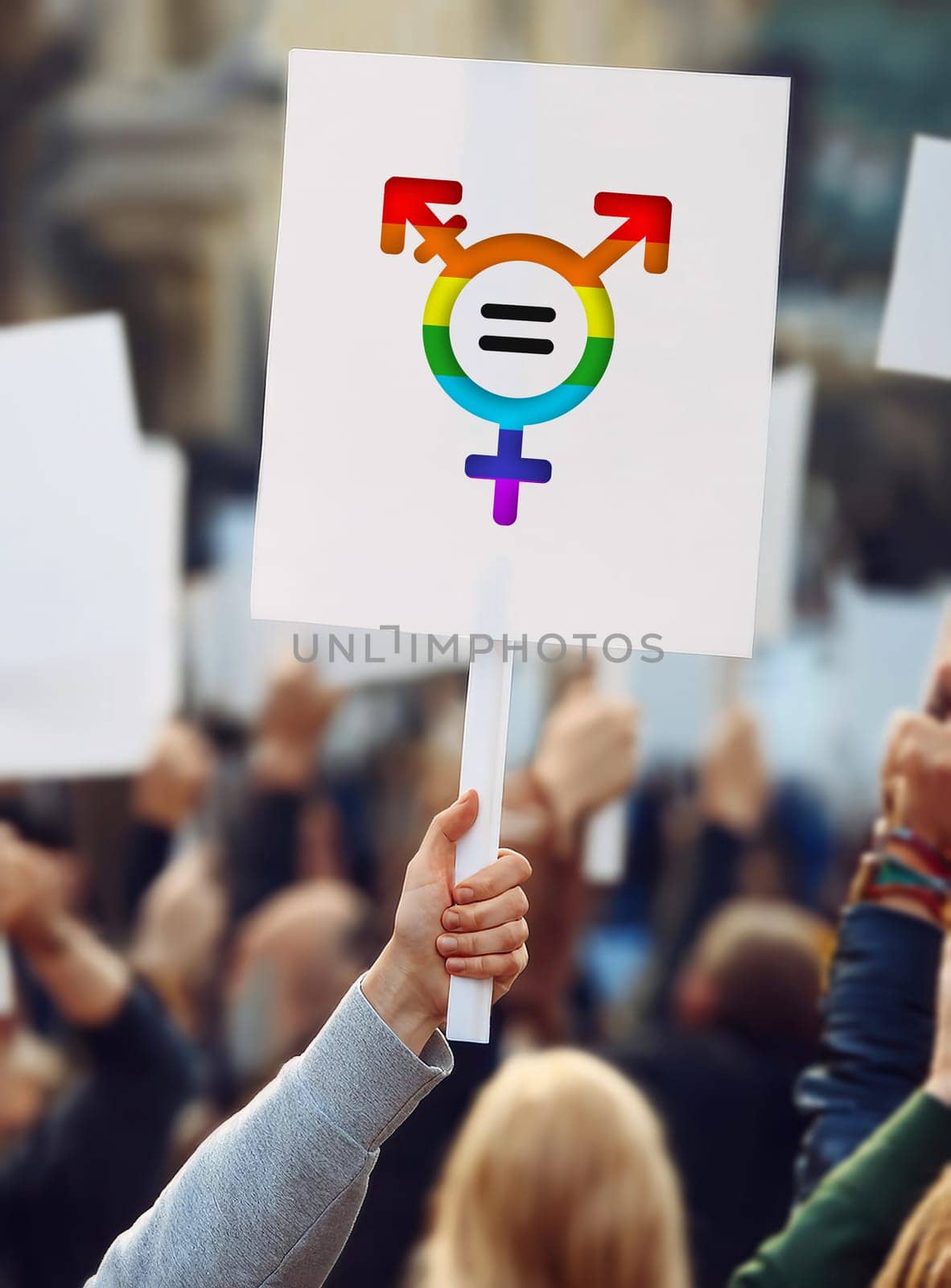 Hand holding a protest banner with transgender symbol in rainbow colors. LGBTQ+ pride rally march for sex equality