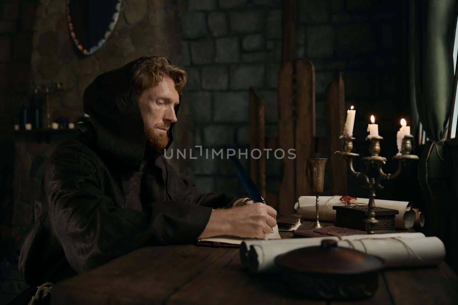 Medieval monk chronicler writing ancient sacred manuscript under candlelight in dark monastery cell