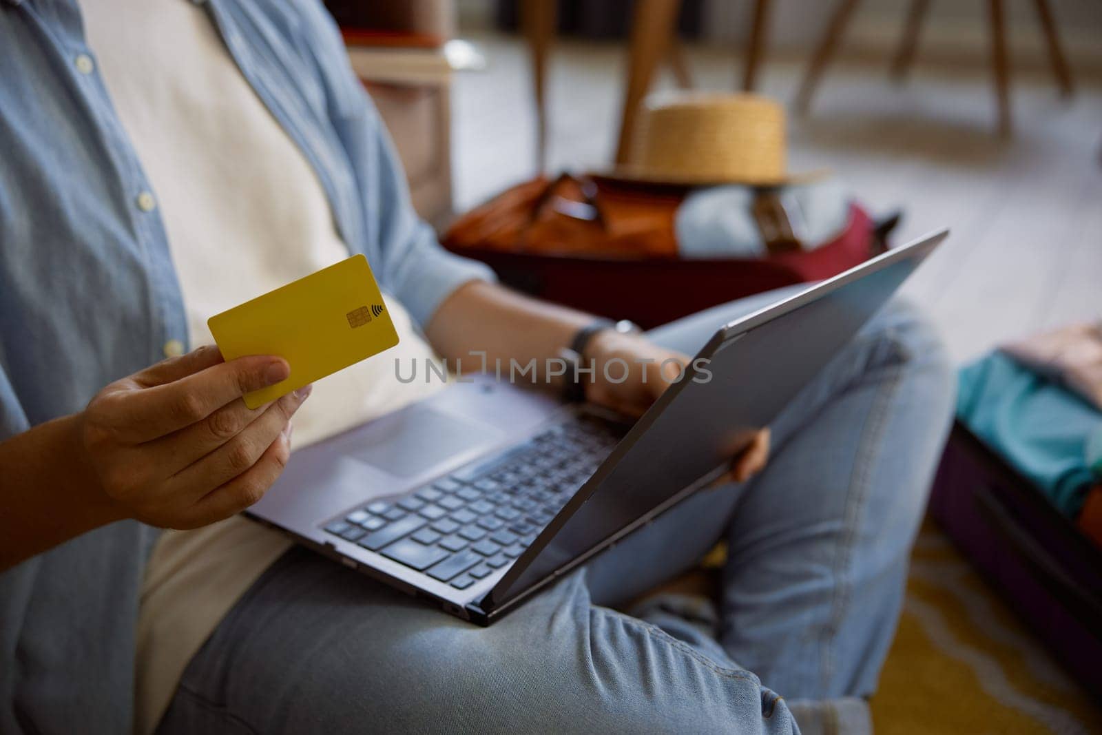 Resort booking and online payment for vacation trip or flight ticket. Closeup shot of male hand holding plastic credit card to buy or make hotel reservation