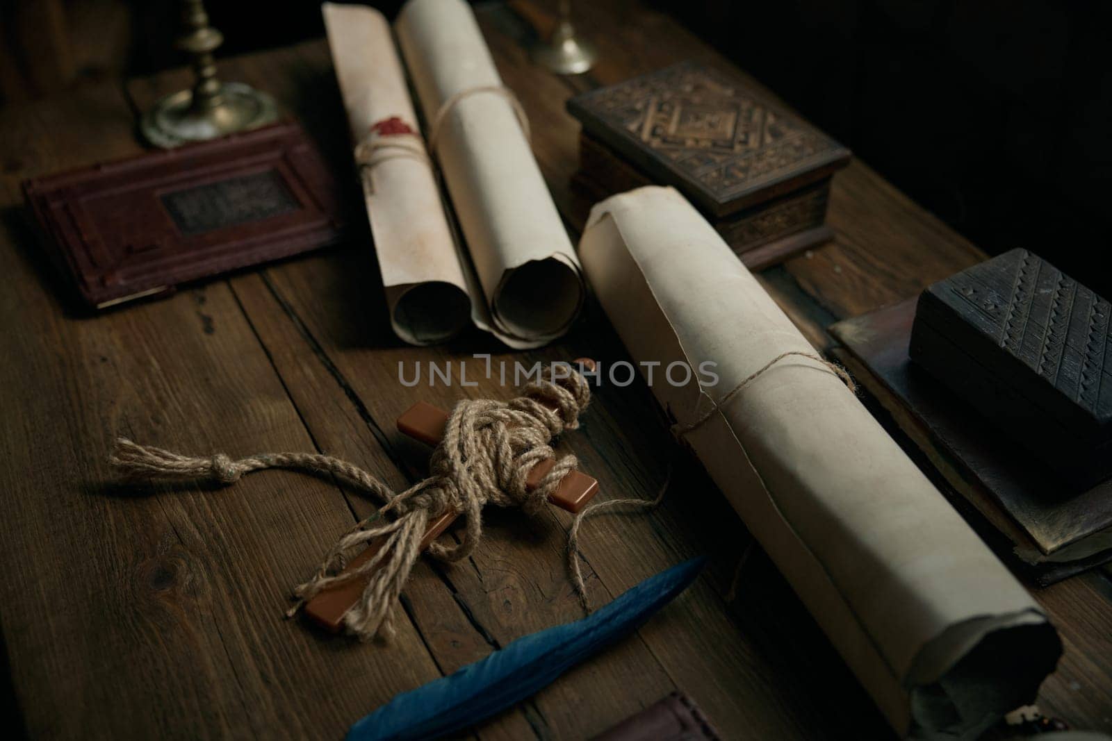 Obsolete medieval wooden table with traditional antique documents, cross and other religious accessories