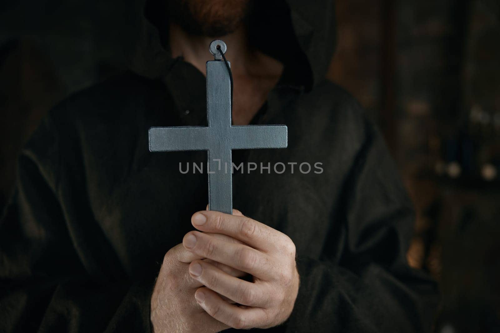 Silver cross in medieval monk hands. Historic priest in monastery