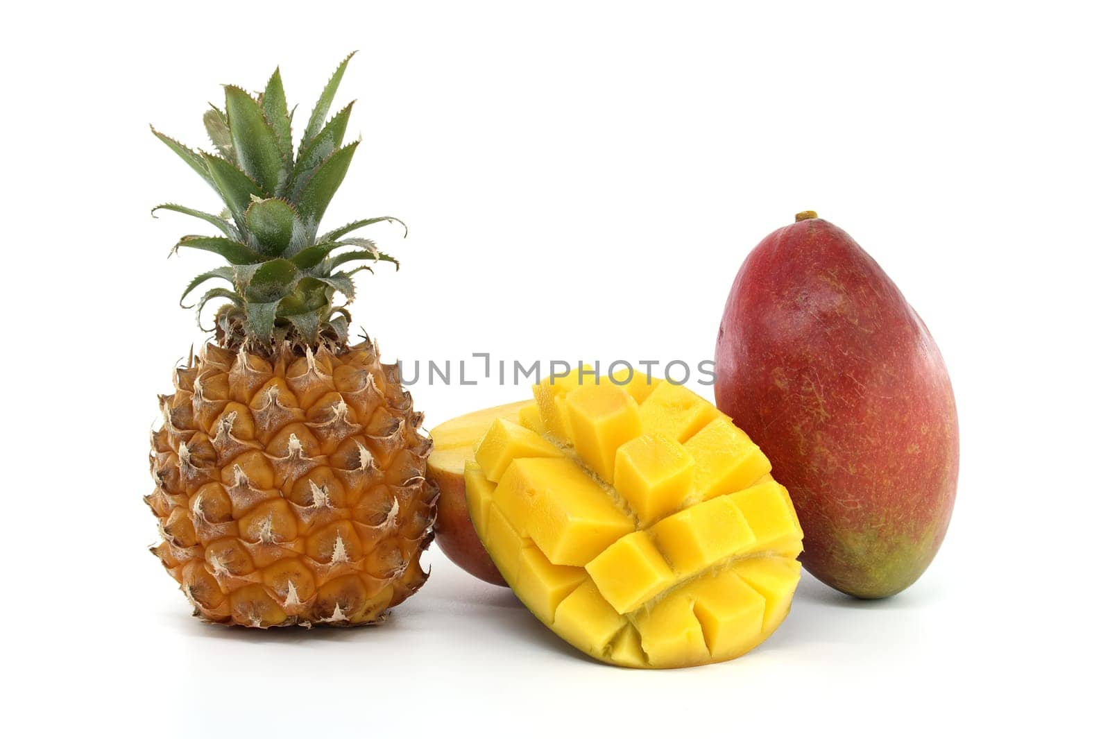 Vivid tropical fruits including a whole pineapple and mango with a diced sliced mango presentation