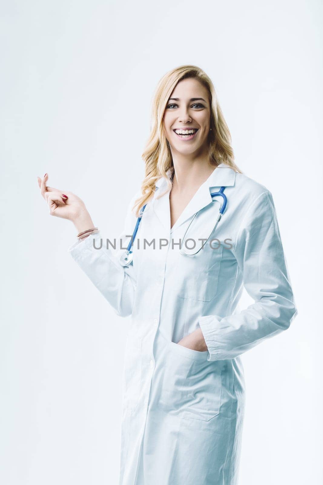 Young female doctor smiling and showing something, imagining the future of medicine with artificial intelligence and automation improving healthcare