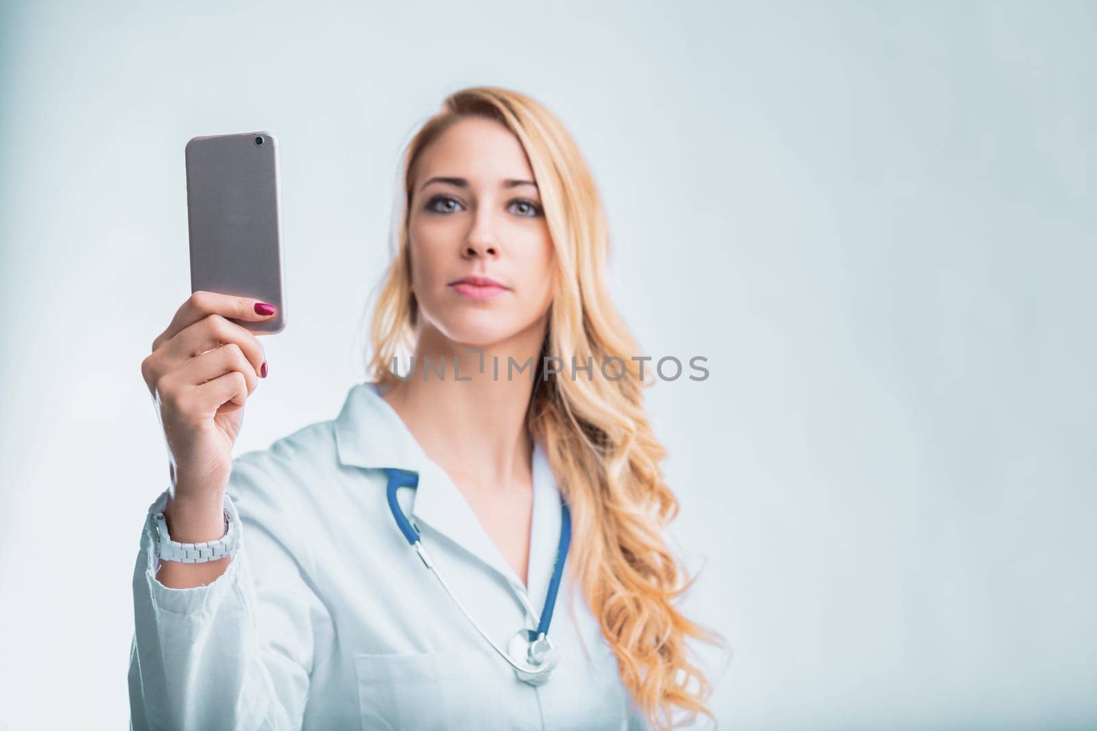 Young female doctor using a smartphone app for remote patient monitoring and ai-powered diagnostics, revolutionizing healthcare with technology