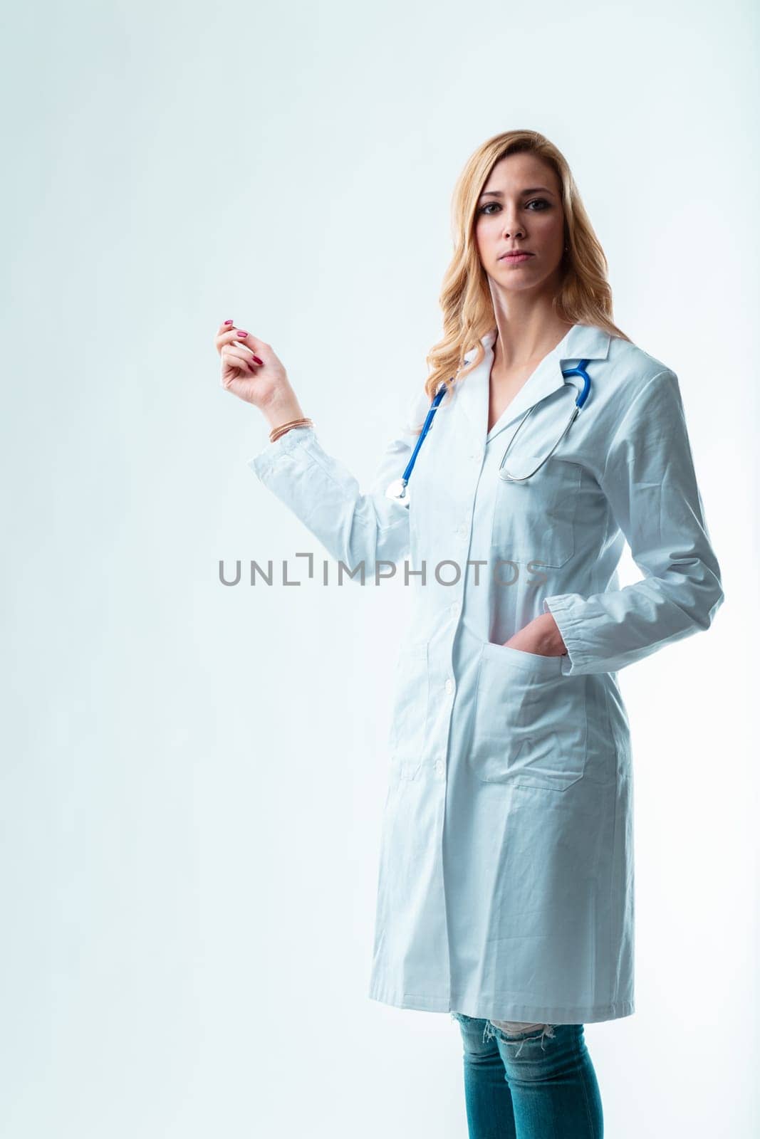 oung blonde doctor points to a copyspace for your item. Potentially a dentist, gynecologist or any medical specialist