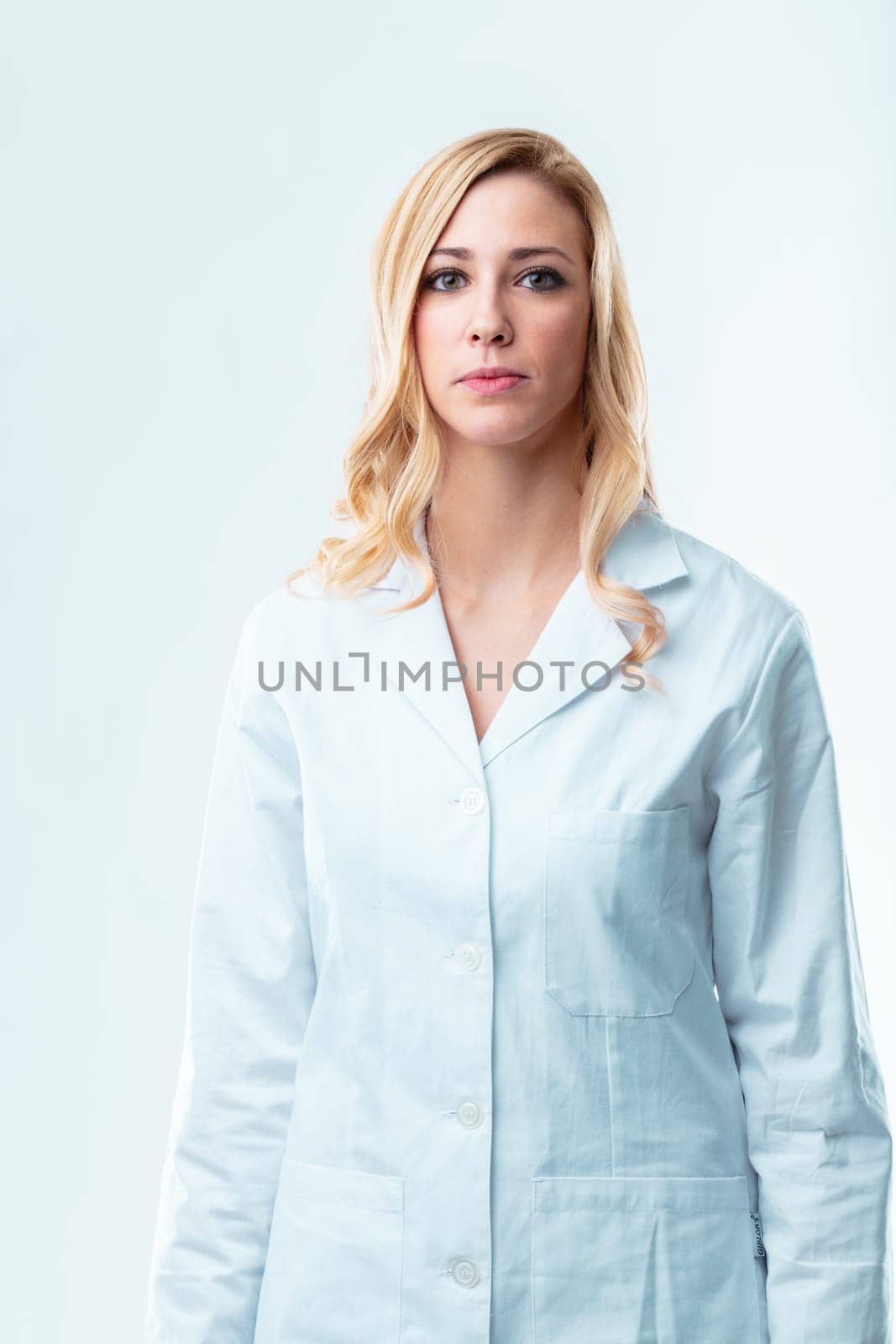 Blonde woman in white coat, skilled and knowledgeable, desires to use expertise for human good, skeptical of ethical overlook