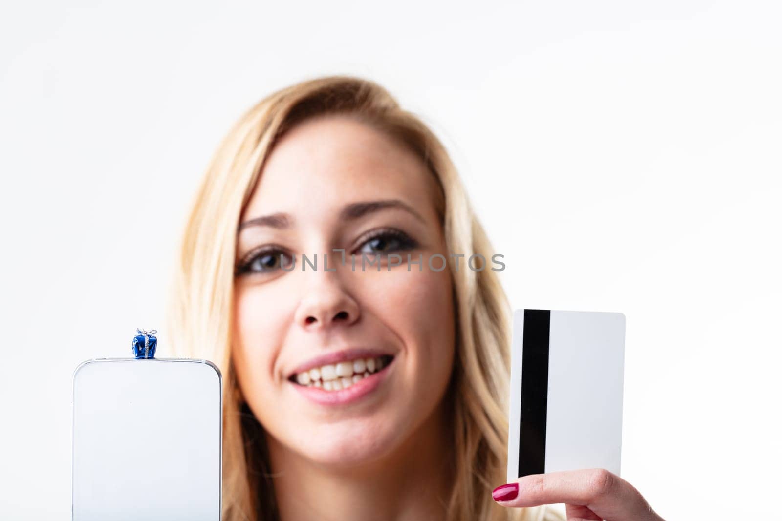 Happy blonde woman with smartphone, credit card for quick online shopping. Convenience in the digital world