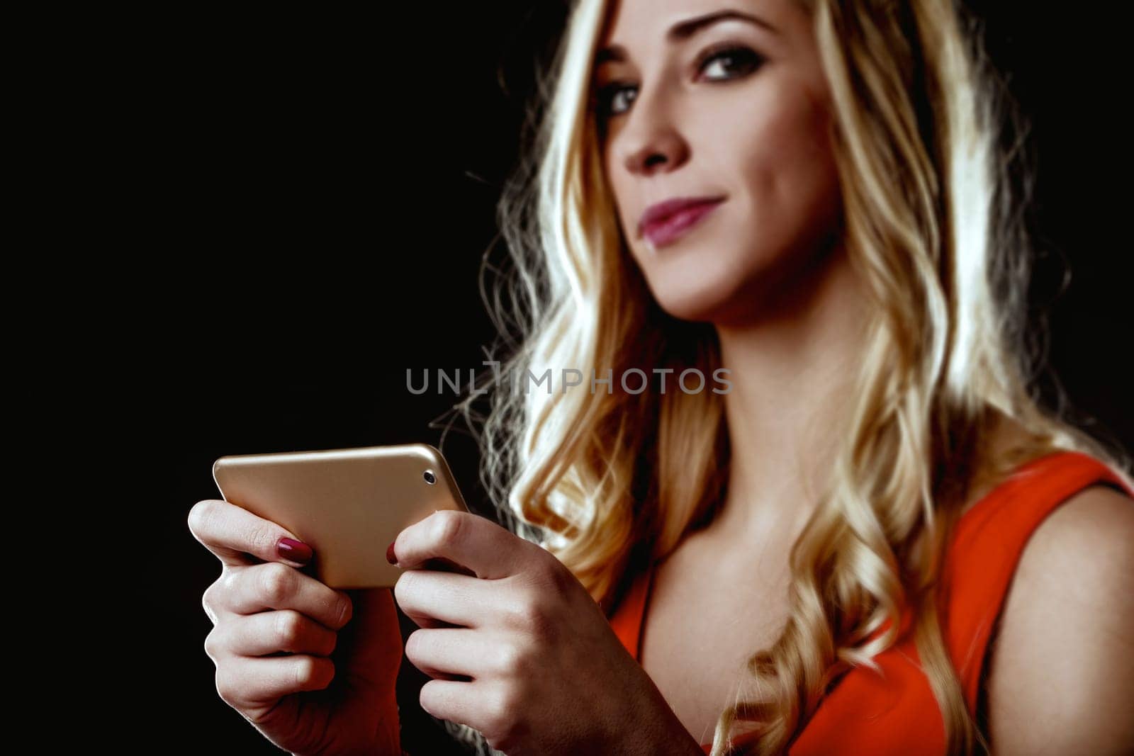 Young woman with blond hair and an elegant red dress is using a smartphone, possibly interacting with artificial intelligence and automation, pondering the impact on her life and future