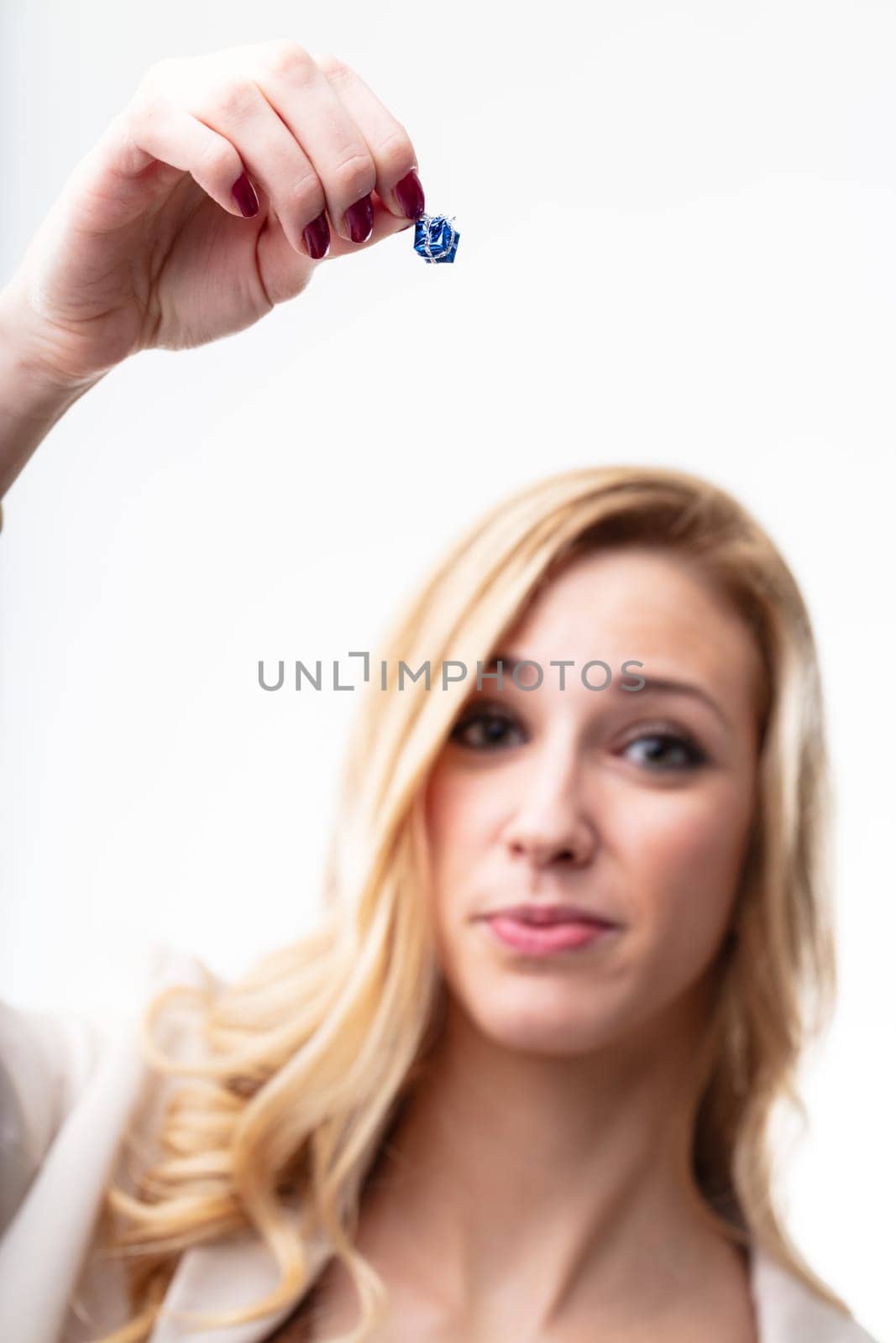 Woman in blurred background, unsatisfied with small gift she's holding. The present is insufficient