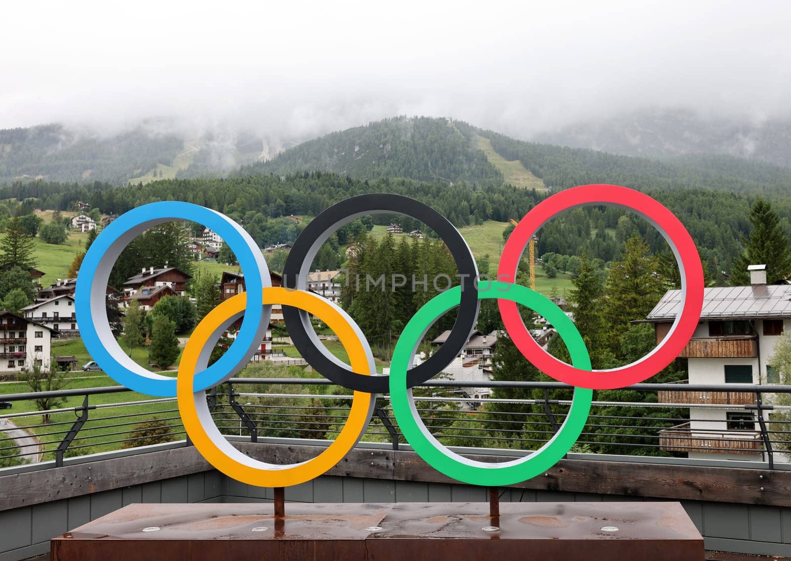 The Olympic rings in Cortina d Ampezzo against the background of the cloud-covered Dolomites. Italy