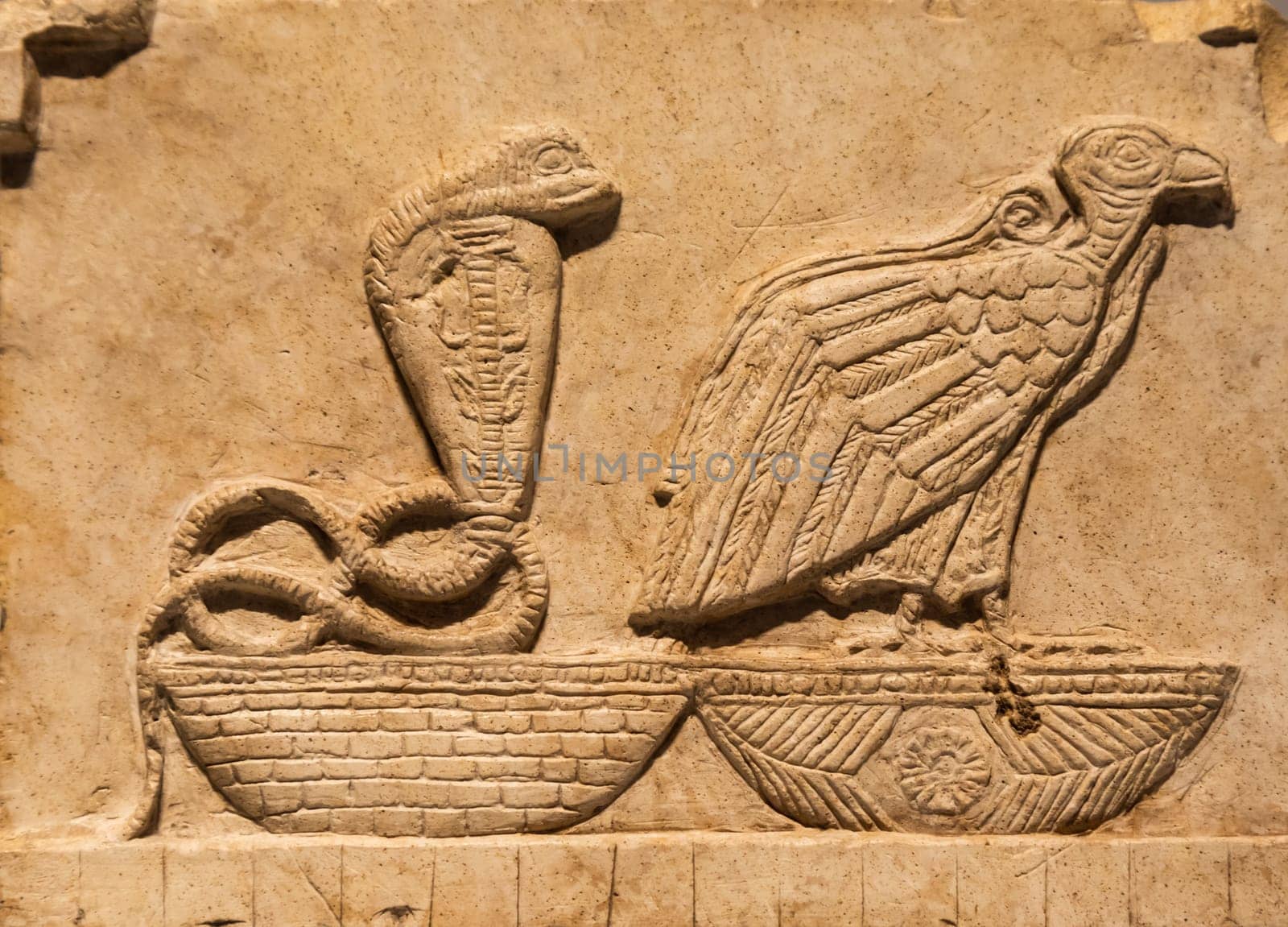 Turin, Italy - 28 December 2023: Egyptian Museum. Plaque with vulture and cobra, limestone, 400 BC