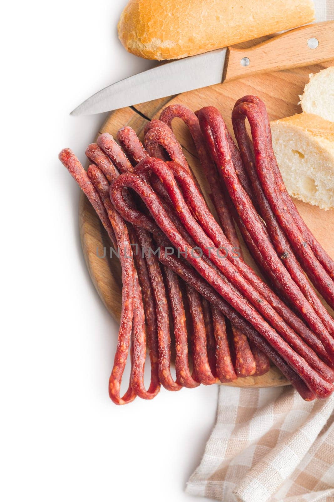 Smoked kabanos. Mini dried thin sausages on a cutting board isolated on white background