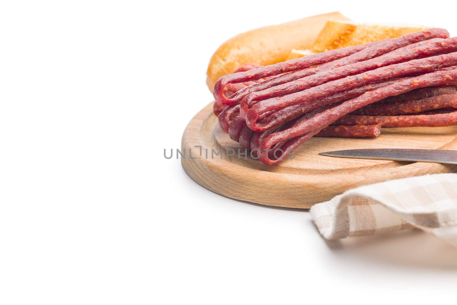 Smoked kabanos. Mini dried thin sausages on a cutting board isolated on white background