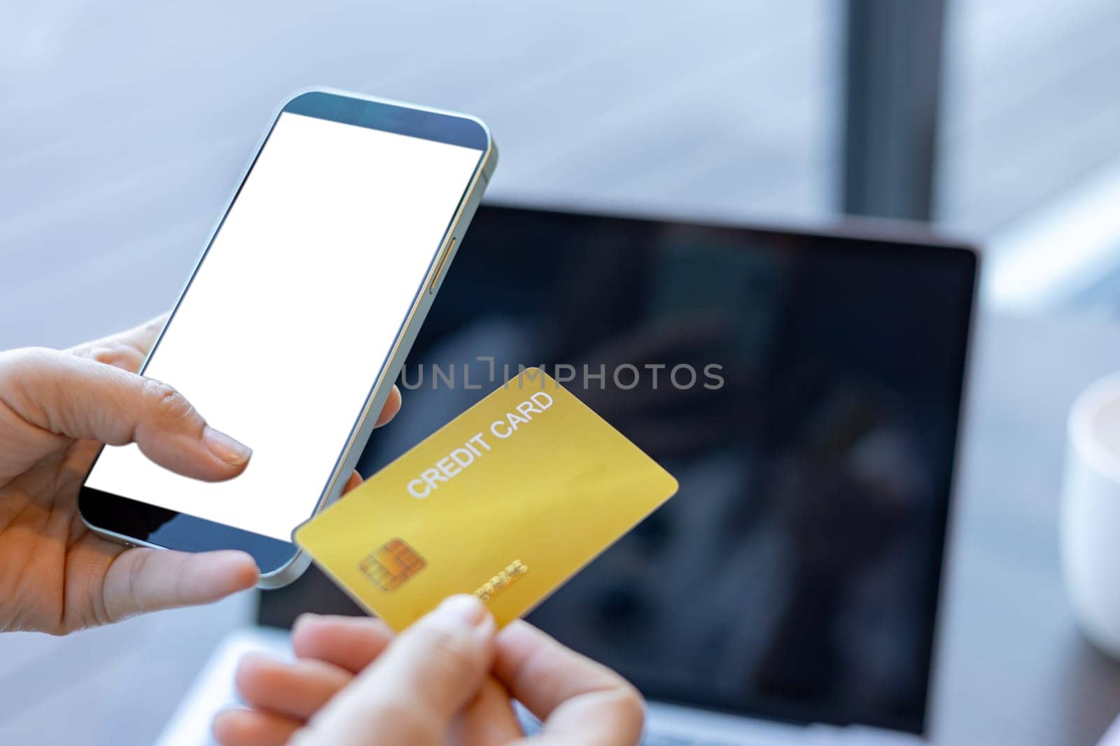Woman hand hold blank smartphone with credit card and money on the table in coffee shop, online shopping concept.
