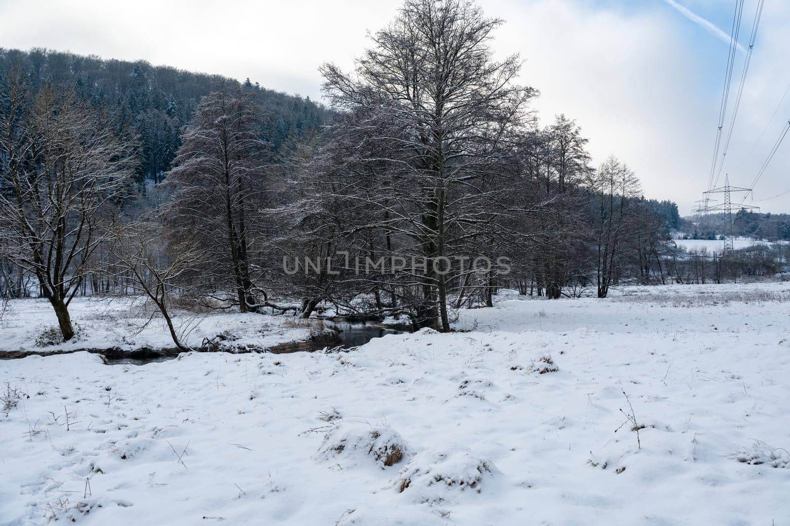 Electricity pole in a winter landscape with a lot of snow and some trees